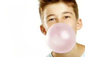 boy make bubble with chew on white background